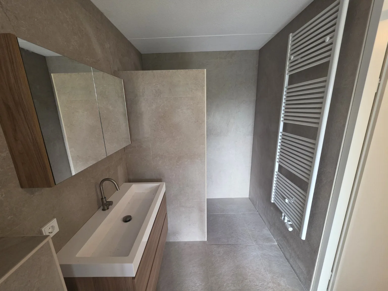 Badkamer met brede wastafel en inloopdouche